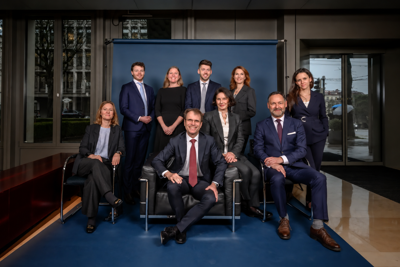 Portrait de groupe de l’équipe de Wilhelm Avocats SA devant un fond bleu
